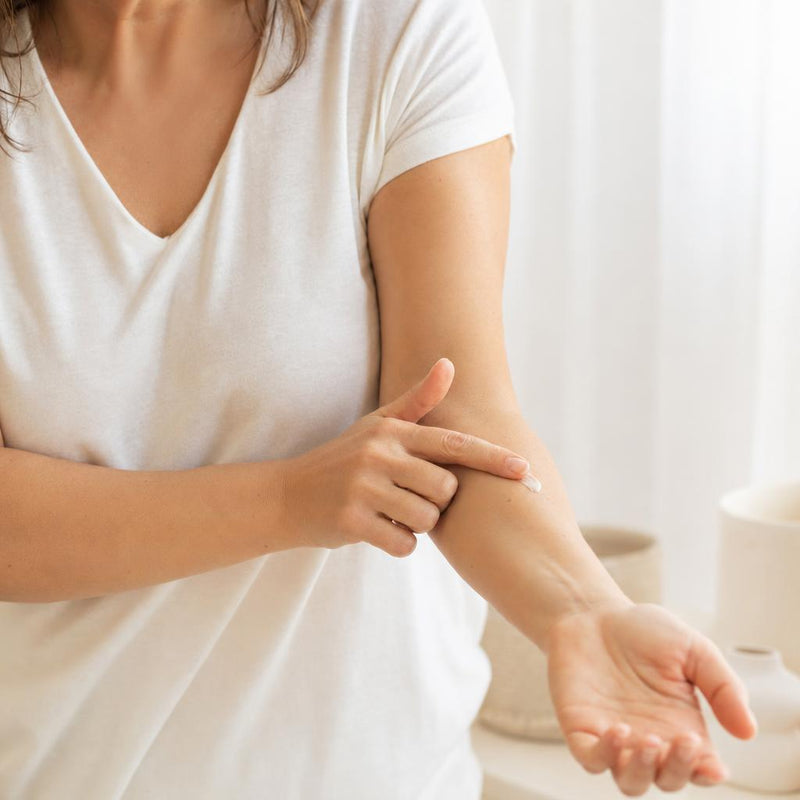 Mujer probando una pizca de crema en el antebrazo